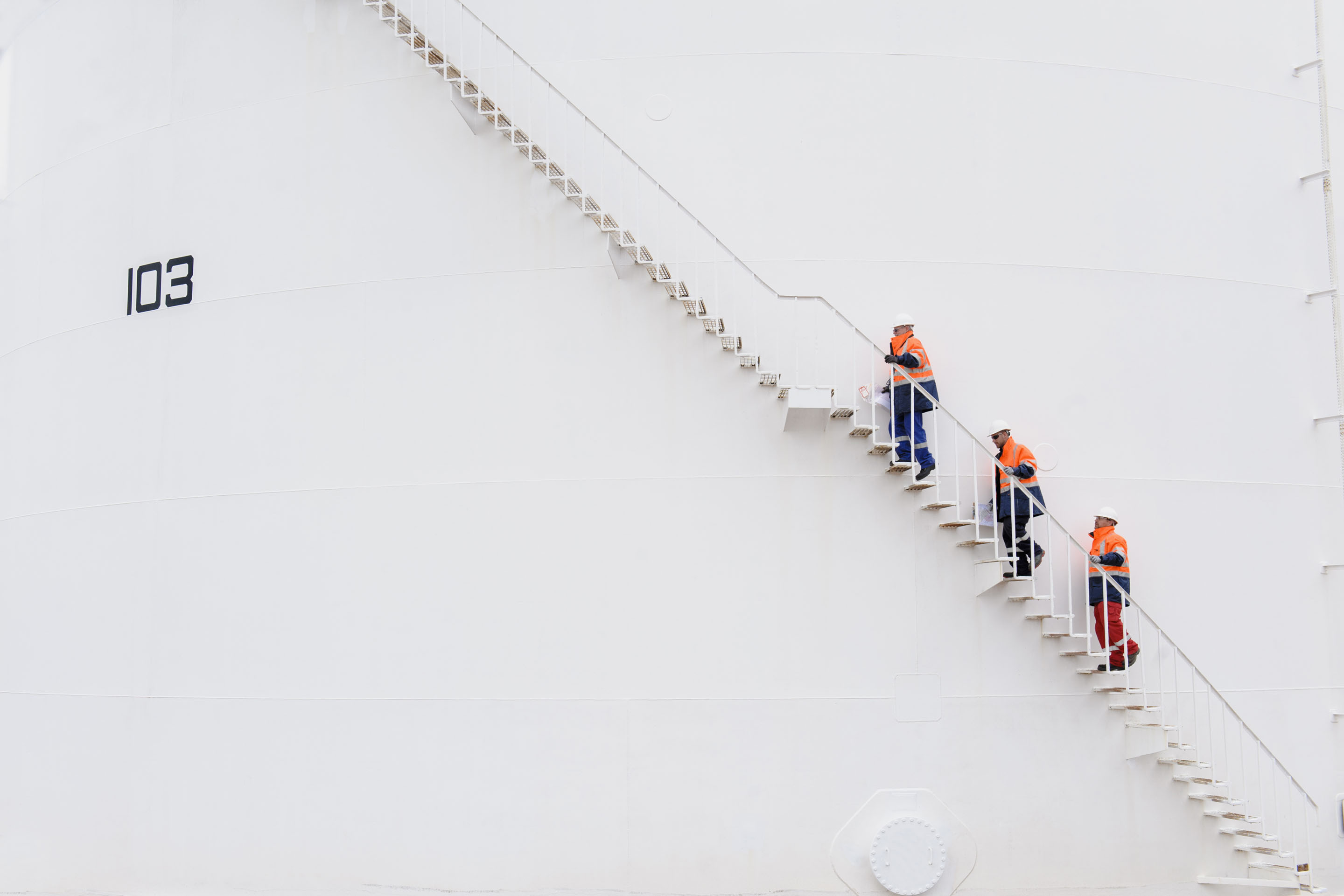 hon-workers-ascending-stairs-white-storage-tank-532029699.jpg